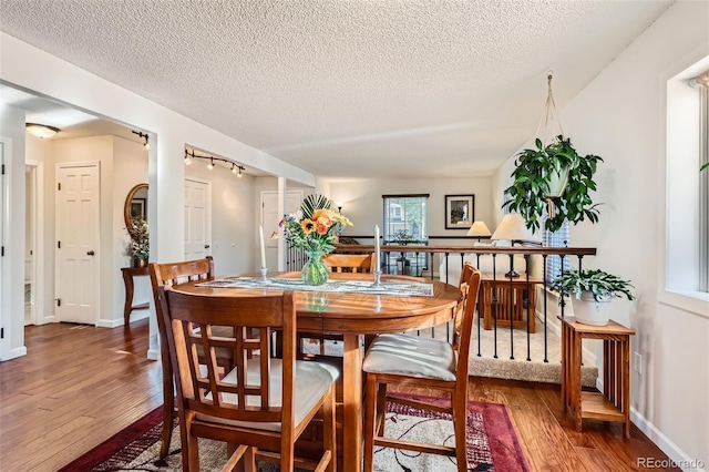 8156 Carr Cir, Arvada, CO 80005 - dining area with hardwood / wood-style floors, track lighting, and a textured ceiling