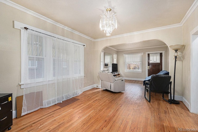 3159 36th Ave, Denver, CO 80211 - living area featuring ornamental molding, arched walkways, light wood-style flooring, baseboards, and a notable chandelier