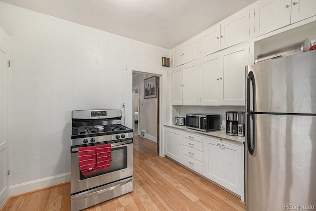 3159 36th Ave, Denver, CO 80211 - kitchen featuring light wood finished floors, stainless steel appliances, light countertops, baseboards, and white cabinetry