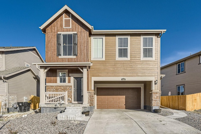 craftsman-style house featuring a garage, fence, covered porch, stone siding, and concrete driveway