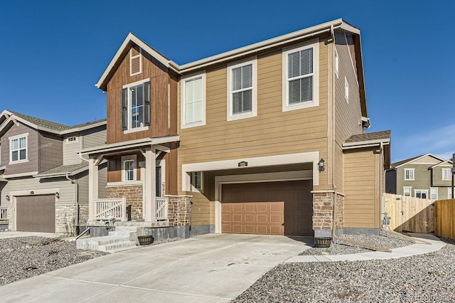 view of front of house featuring a garage, fence, stone siding, concrete driveway, and a porch