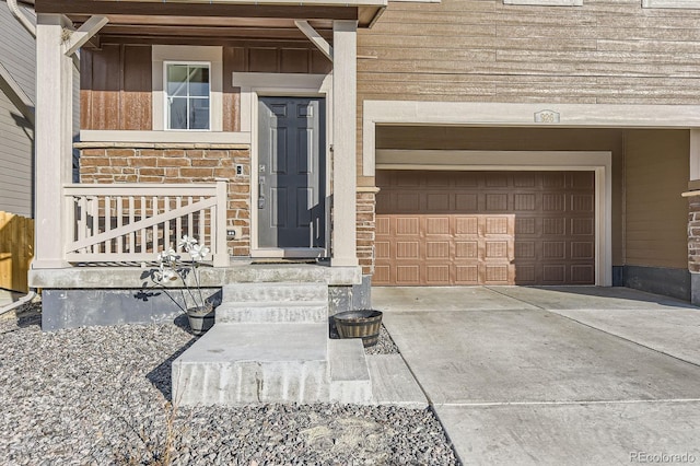 doorway to property with driveway and stone siding