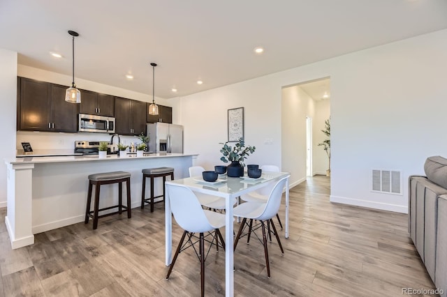 dining area featuring visible vents, recessed lighting, light wood-style flooring, and baseboards