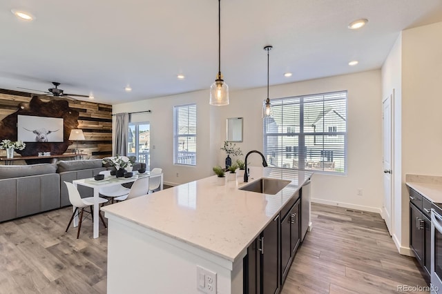 kitchen with ceiling fan, light wood-type flooring, recessed lighting, a sink, and decorative light fixtures