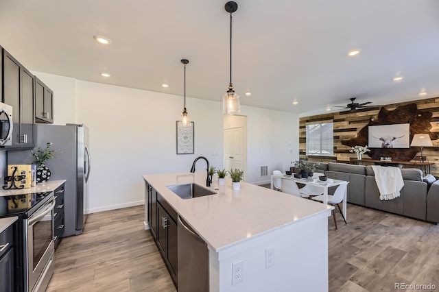 kitchen featuring light wood-style floors, ceiling fan, recessed lighting, a sink, and appliances with stainless steel finishes