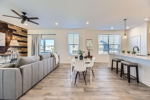 dining area with baseboards, ceiling fan, recessed lighting, and light wood-style flooring