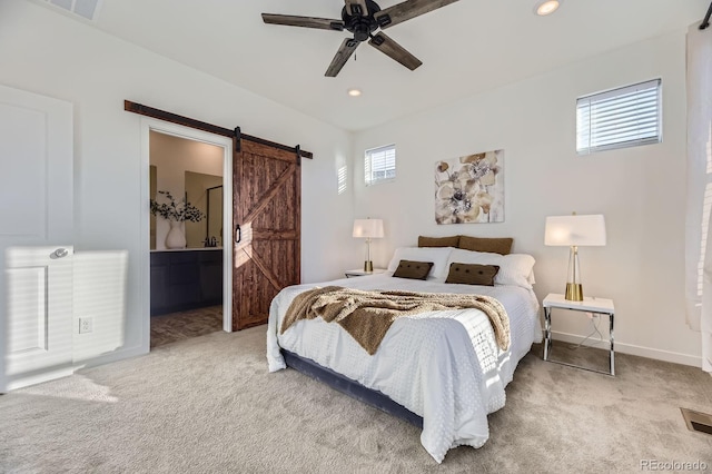 bedroom with carpet flooring, a barn door, and multiple windows