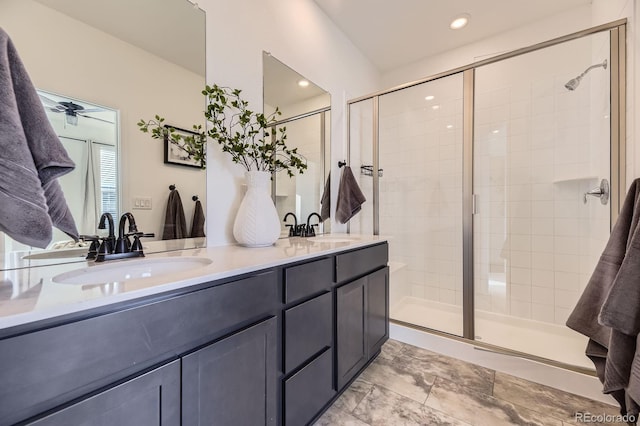 full bathroom with double vanity, a shower stall, and a sink