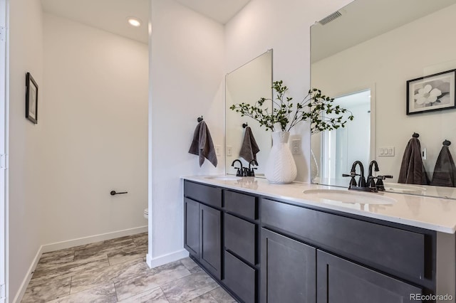 full bath featuring double vanity, visible vents, and a sink