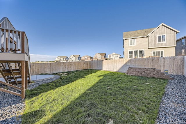 view of yard featuring a fenced backyard and stairs