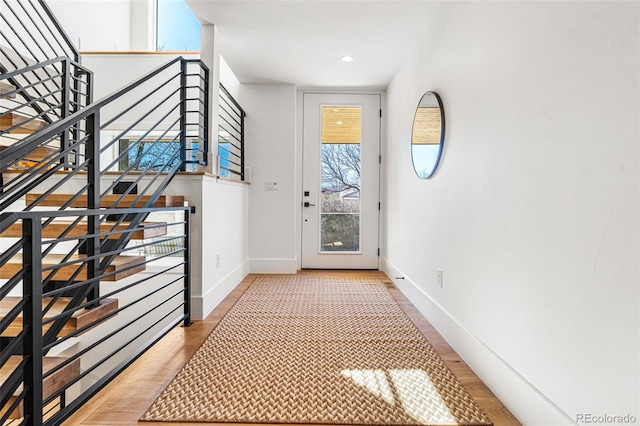 doorway with stairway, baseboards, light wood finished floors, and recessed lighting