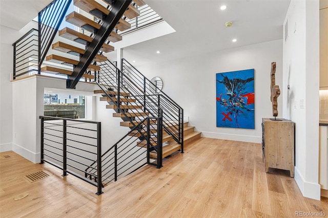 staircase with visible vents, wood finished floors, recessed lighting, and baseboards