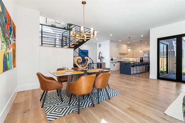 dining space featuring recessed lighting, stairway, baseboards, a chandelier, and light wood-style floors