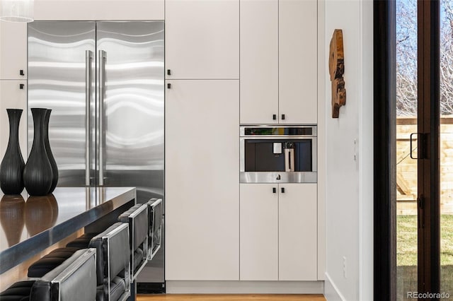 kitchen with modern cabinets, white cabinets, and appliances with stainless steel finishes