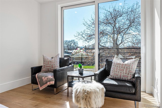 sitting room with baseboards and light wood-type flooring