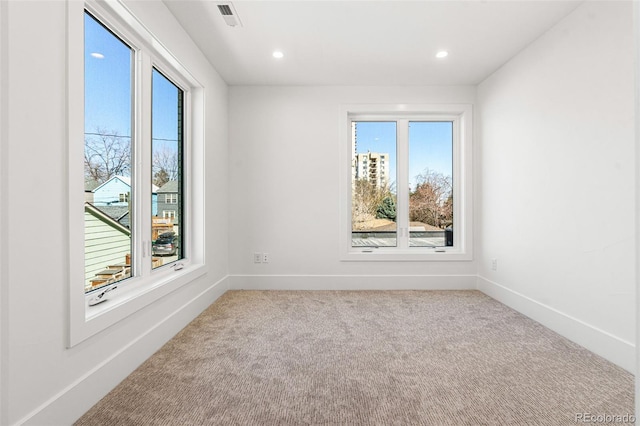 spare room featuring baseboards, visible vents, recessed lighting, and light carpet