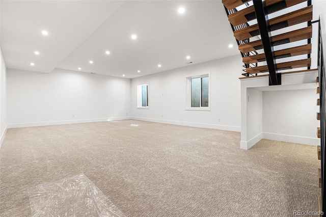 unfurnished living room with light colored carpet, recessed lighting, and baseboards