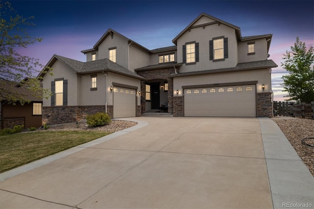 17452 W 83rd Pl, Arvada, CO 80007 - view of front of house featuring stucco siding, stone siding, an attached garage, driveway, and a yard