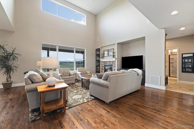 17452 W 83rd Pl, Arvada, CO 80007 - living area featuring wood finished floors, a high ceiling, baseboards, a fireplace, and recessed lighting
