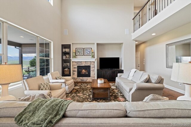 17452 W 83rd Pl, Arvada, CO 80007 - living room with a towering ceiling, healthy amount of natural light, a fireplace, baseboards, and wood finished floors