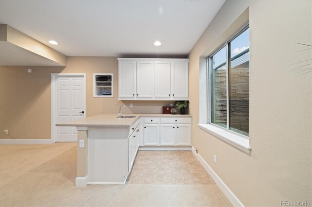 17452 W 83rd Pl, Arvada, CO 80007 - kitchen with a sink, a peninsula, white cabinetry, light countertops, and recessed lighting