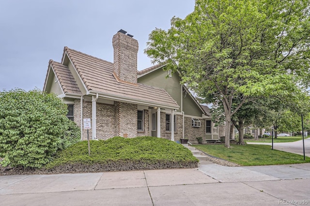 2299 Ranch Dr, Westminster, CO 80234 - view of home's exterior featuring a chimney, brick siding, a yard, and a tiled roof