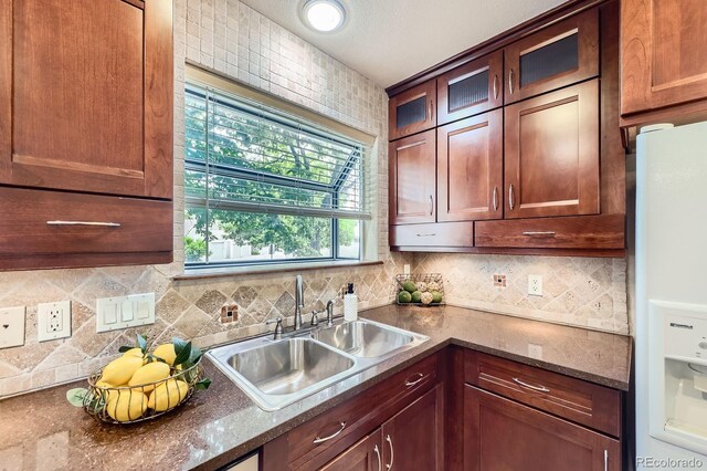 2299 Ranch Dr, Westminster, CO 80234 - kitchen with white fridge with ice dispenser, a sink, decorative backsplash, and glass insert cabinets