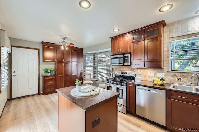 2299 Ranch Dr, Westminster, CO 80234 - kitchen with stainless steel appliances, a sink, ceiling fan, a kitchen island, and light wood finished floors