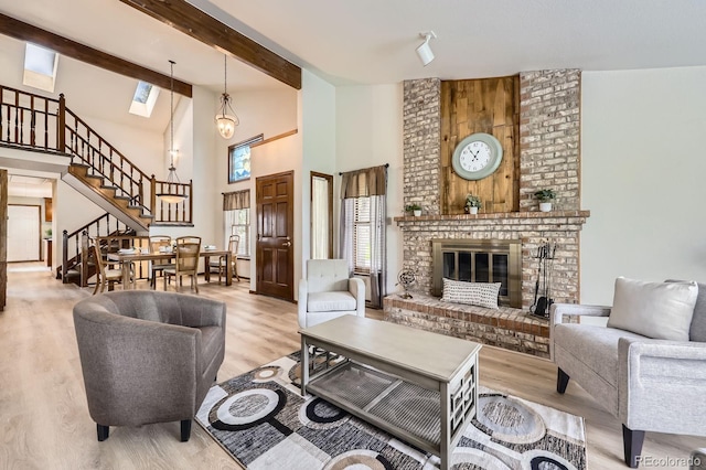 2299 Ranch Dr, Westminster, CO 80234 - living area with stairway, high vaulted ceiling, wood finished floors, a fireplace, and beam ceiling