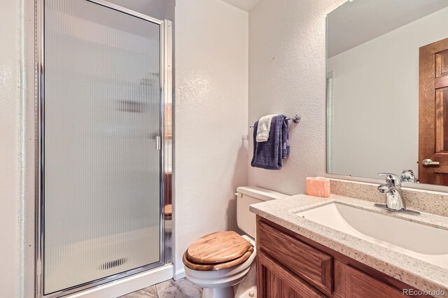 2299 Ranch Dr, Westminster, CO 80234 - bathroom featuring toilet, vanity, a shower stall, and a textured wall