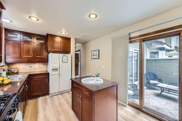 2299 Ranch Dr, Westminster, CO 80234 - kitchen with white refrigerator with ice dispenser, a sink, light wood finished floors, backsplash, and range with gas cooktop