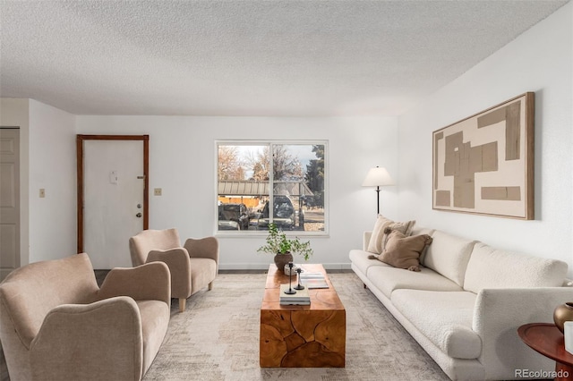 living area featuring a textured ceiling and baseboards