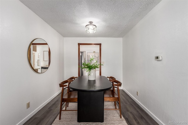 dining area featuring a textured ceiling, wood finished floors, and baseboards