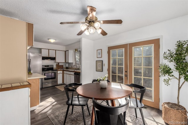 dining area featuring a textured ceiling, ceiling fan, french doors, and dark wood-type flooring