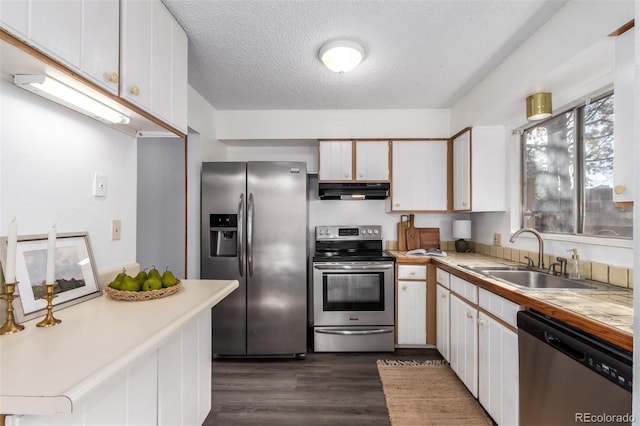 kitchen with stainless steel appliances, dark wood-type flooring, a sink, a textured ceiling, and under cabinet range hood