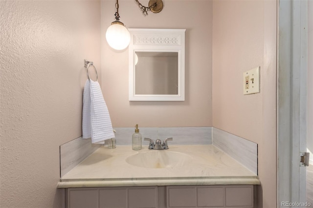 bathroom featuring a textured wall and vanity