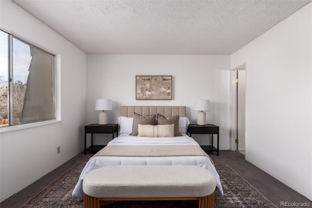 bedroom featuring dark colored carpet and a textured ceiling