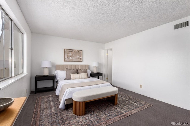 carpeted bedroom with a textured ceiling and visible vents