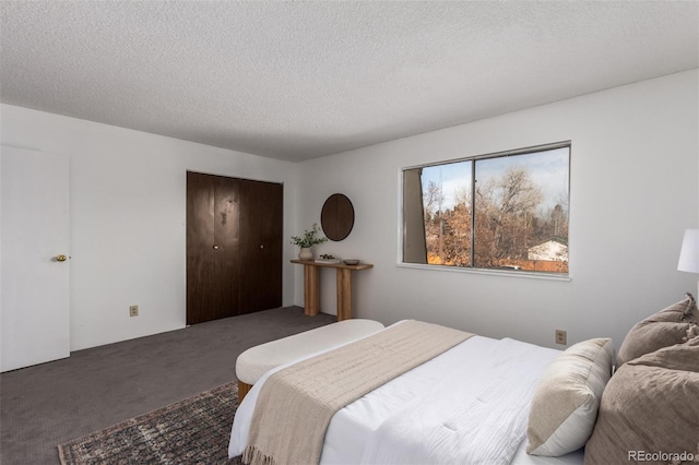 carpeted bedroom with a textured ceiling and a closet