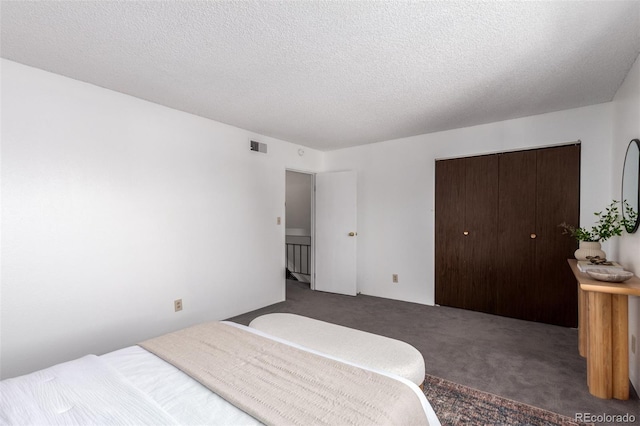 bedroom featuring carpet, a closet, visible vents, and a textured ceiling