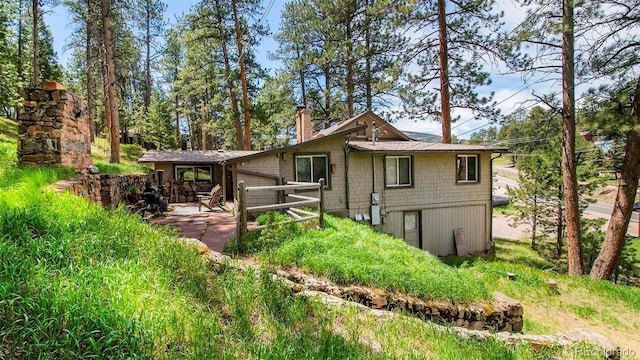 28958 Buffalo Park Rd, Evergreen, CO 80439 - view of front of property with a chimney and a patio area