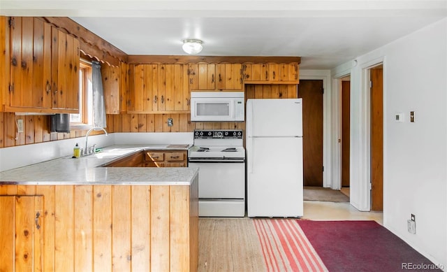28958 Buffalo Park Rd, Evergreen, CO 80439 - kitchen with white appliances, light countertops, a peninsula, and brown cabinets