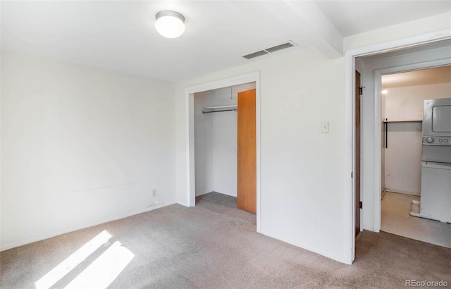 28958 Buffalo Park Rd, Evergreen, CO 80439 - unfurnished bedroom featuring stacked washing machine and dryer, carpet, and a closet