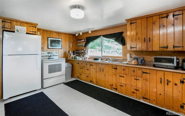 28958 Buffalo Park Rd, Evergreen, CO 80439 - kitchen with white appliances, rail lighting, wooden walls, brown cabinets, and light countertops