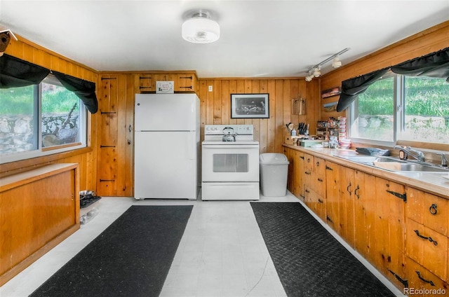 28958 Buffalo Park Rd, Evergreen, CO 80439 - kitchen featuring white appliances, track lighting, healthy amount of natural light, wood walls, and brown cabinets