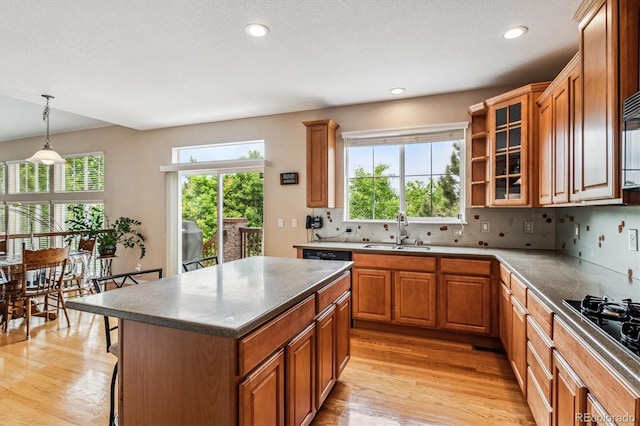 26155 E Euclid Dr, Aurora, CO 80016 - kitchen featuring light wood finished floors, brown cabinets, glass insert cabinets, recessed lighting, and backsplash