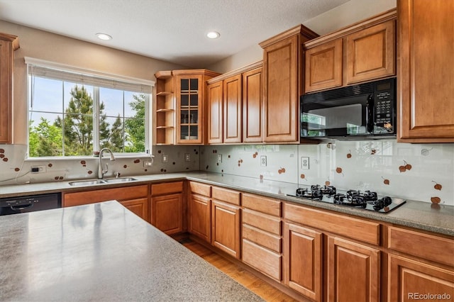 26155 E Euclid Dr, Aurora, CO 80016 - kitchen with black appliances, light wood-style flooring, brown cabinetry, backsplash, and recessed lighting
