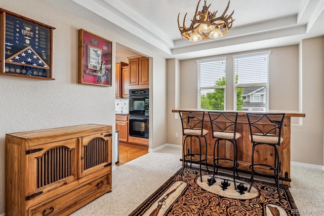 26155 E Euclid Dr, Aurora, CO 80016 - kitchen with a raised ceiling, a chandelier, and light colored carpet