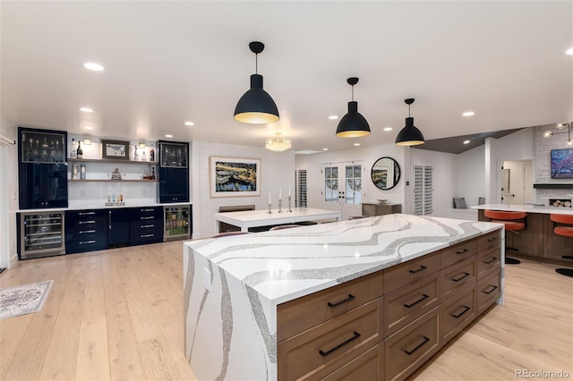 1 Club Ln, Littleton, CO 80123 - kitchen with wine cooler, a center island, light wood-type flooring, decorative light fixtures, and recessed lighting