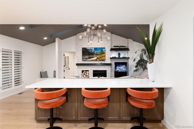 1 Club Ln, Littleton, CO 80123 - bar featuring vaulted ceiling, a fireplace, light wood-style flooring, a chandelier, and recessed lighting